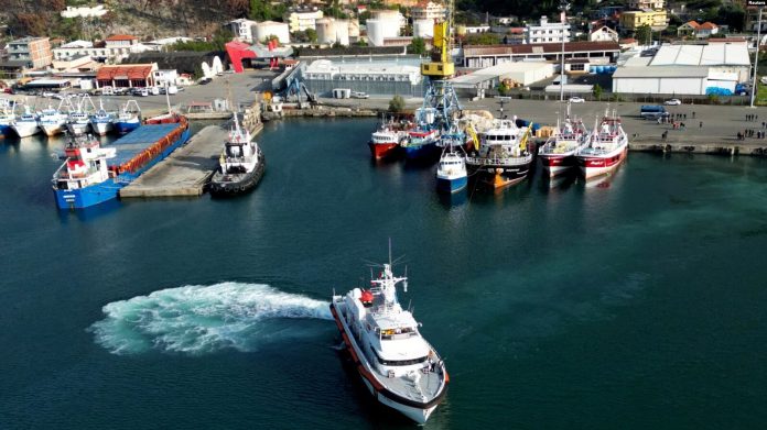 Një anije e rojes bregdetare italiane niset për në Itali me emigrantë, të cilët u kapën në det dhe më pas u dërguan në një qendër pritjeje në Shqipëri, pasi një gjykatë në Romë urdhëroi kthimin e tyre, Shëngjin, Shqipëri, 19 tetor 2024.