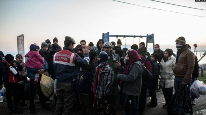 Emigrantët sirianë dhe afganë presin pasi kapen nga policia turke.