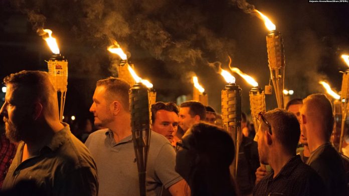 Supremacistët e bardhë gjatë një marshi me flakadanë në Sharlotsvill të SHBA-së më 11 gusht 2017. Në këtë marsh ishte i pranishëm edhe asistenti politik në Ambasadën hungareze në SHA, Taylor Ragg.
