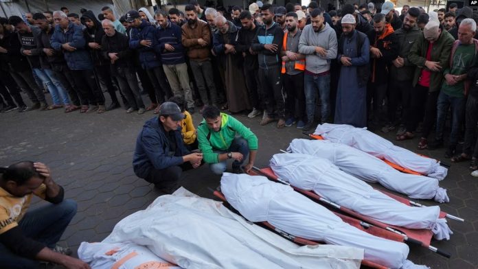 Palestinezët qëndrojnë pranë familjarëve të vrarë në sulmet izraelite në Maghazi në Rripin e Gazës, përderisa presin varrimin e tyre më 14 nëntor, 2024