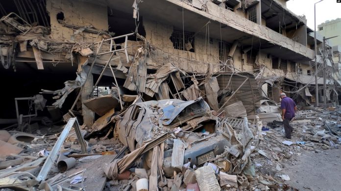 Një burrë kontrollon dyqanin e tij të shkatërruar në një rrugë që u godit nga një sulm ajror izraelit në Dahiyeh, në periferinë jugore të Bejrutit, Liban, të enjten, 14 nëntor 2024.