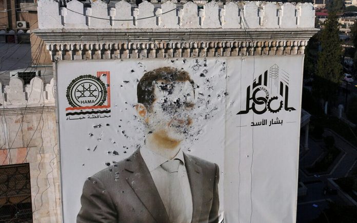 Kjo fotografi tregon një portret të mbushur me plumba të presidentit sirian Bashar al-Assad që zbukuron ndërtesën e bashkisë së Hamës pasi ajo u prish pas kapjes së qytetit nga luftëtarët anti-qeveritare, më 6 dhjetor 2024. (AFP)