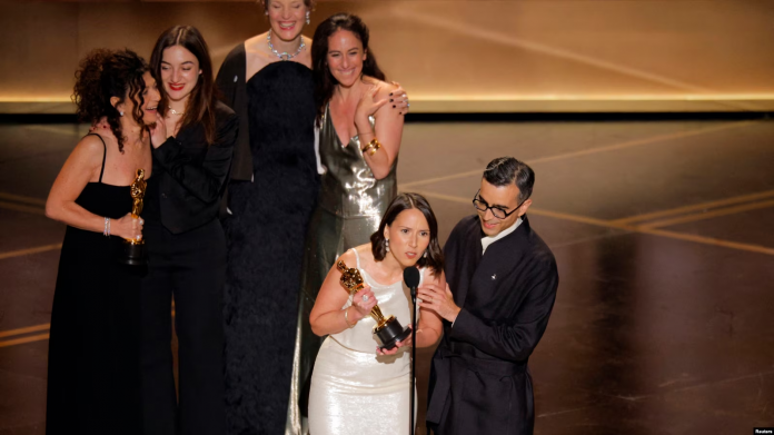 Luana Bajrami (e dyta majtas, rreshti mbrapa) gjatë pranimit të Çmimit Oscar.