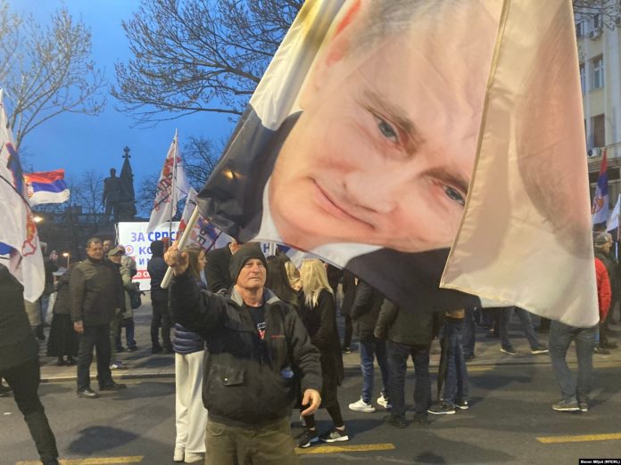 Portreti i presidentit rus, Vladimir Putin, bartet nga një protestues në Beograd më 17 mars 2026.